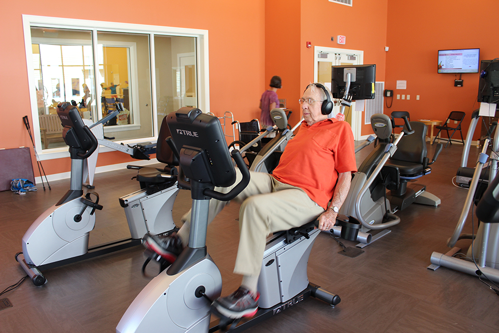 Resident uses bike in fitness center